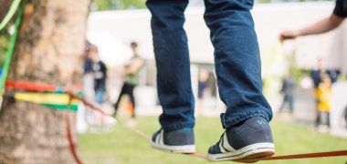 Eine Person balanciert auf einer Slackline