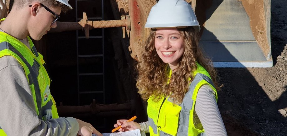 Zwei angehende Bauingenieur*innen (Bachelor of Engineering) schauen auf einen Plan.