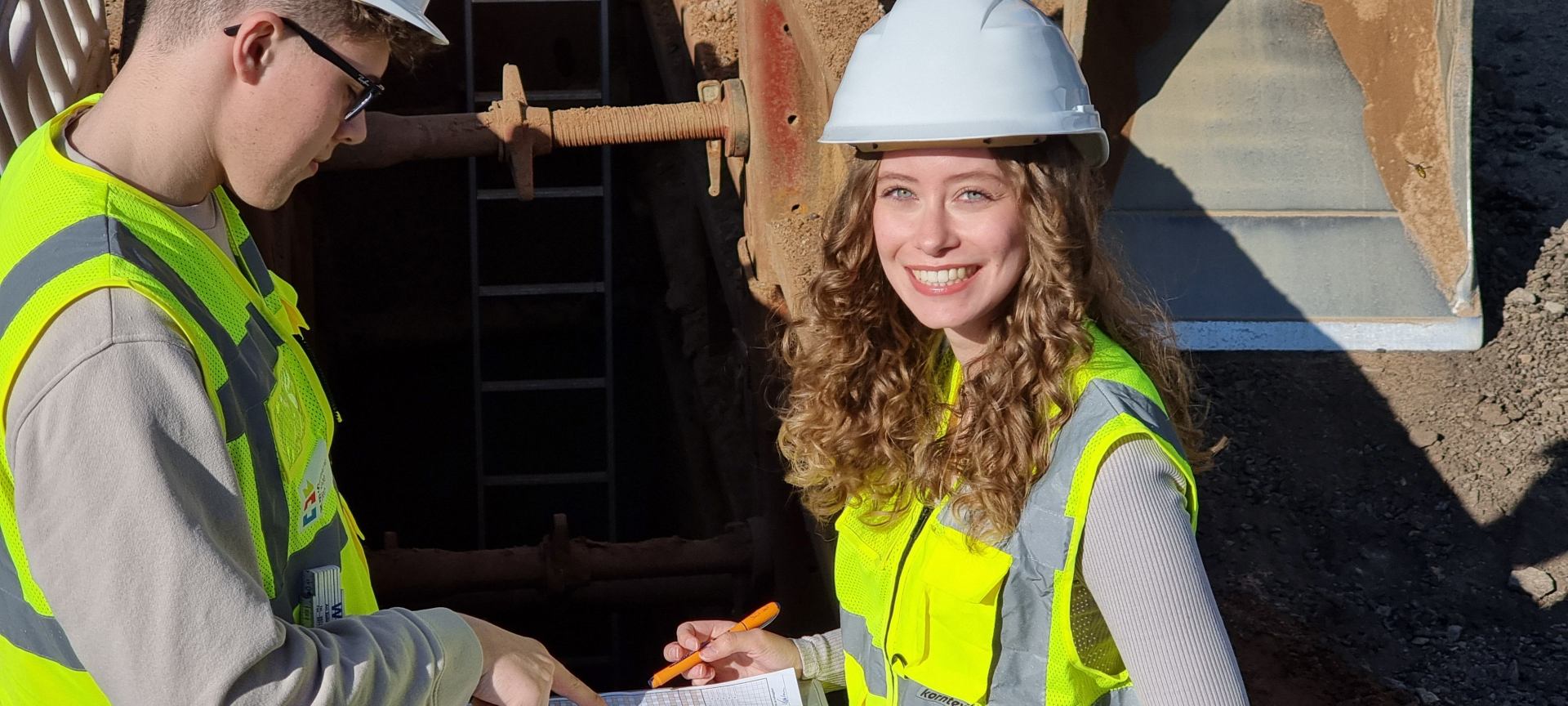 Zwei angehende Bauingenieur*innen (Bachelor of Engineering) schauen auf einen Plan.