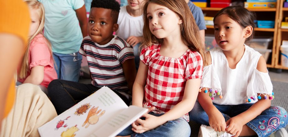 Bilderbuchkino Kinder hören einer Geschichte zu