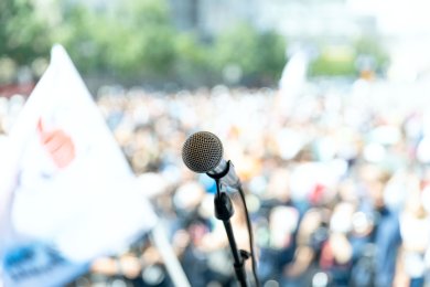 Demonstration Vortrag Rede Ein Mikrofon vor einer großen Menschenmenge