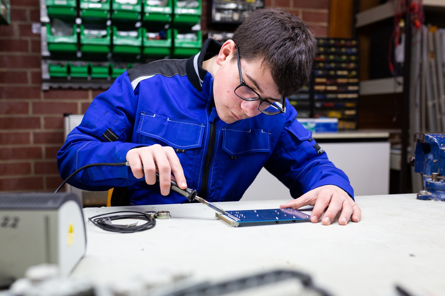 Junger Mann arbeitet mit einem Lötkolben