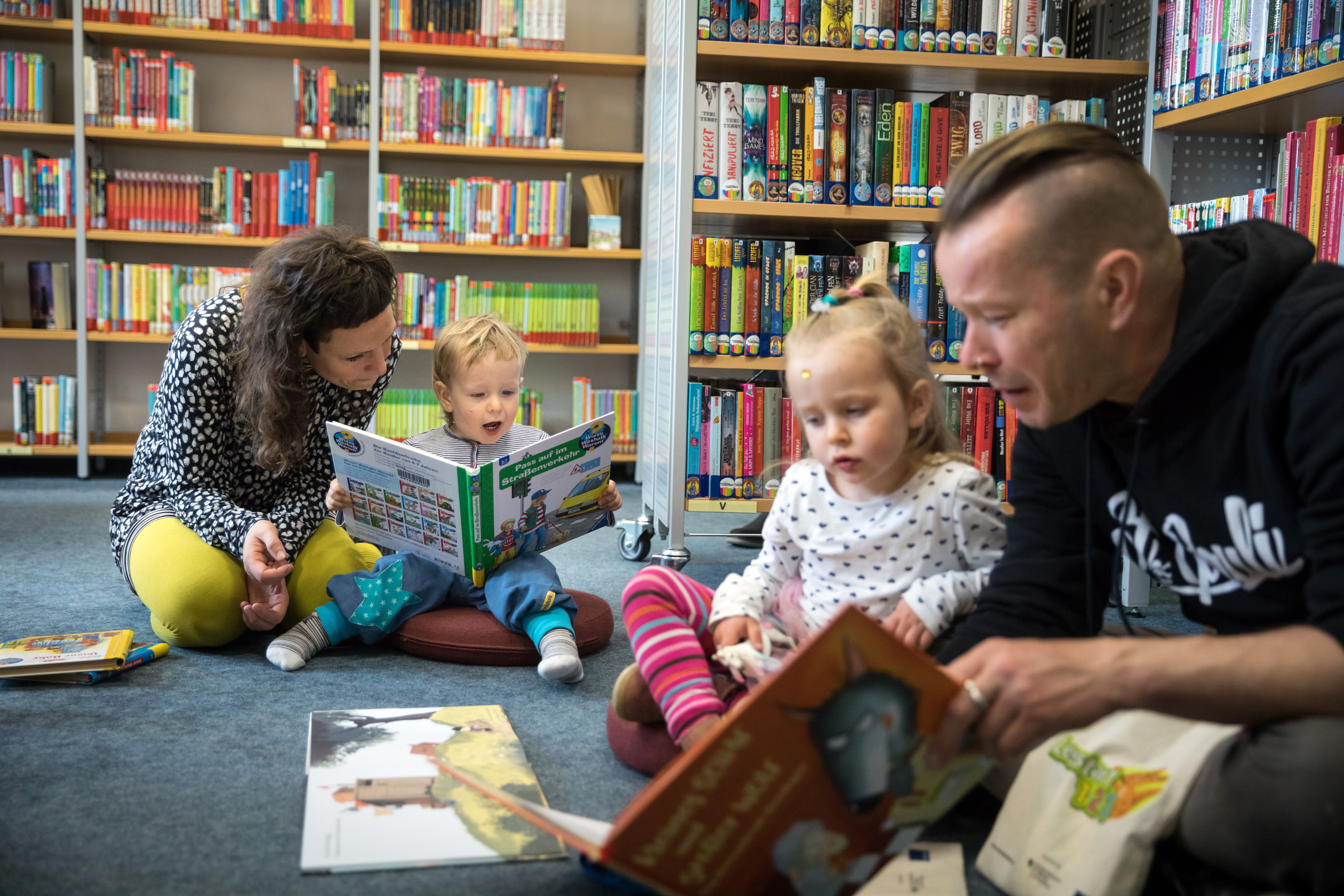 Familie liest gemeinsam ein Buch Familie liest gemeinsam ein Buch