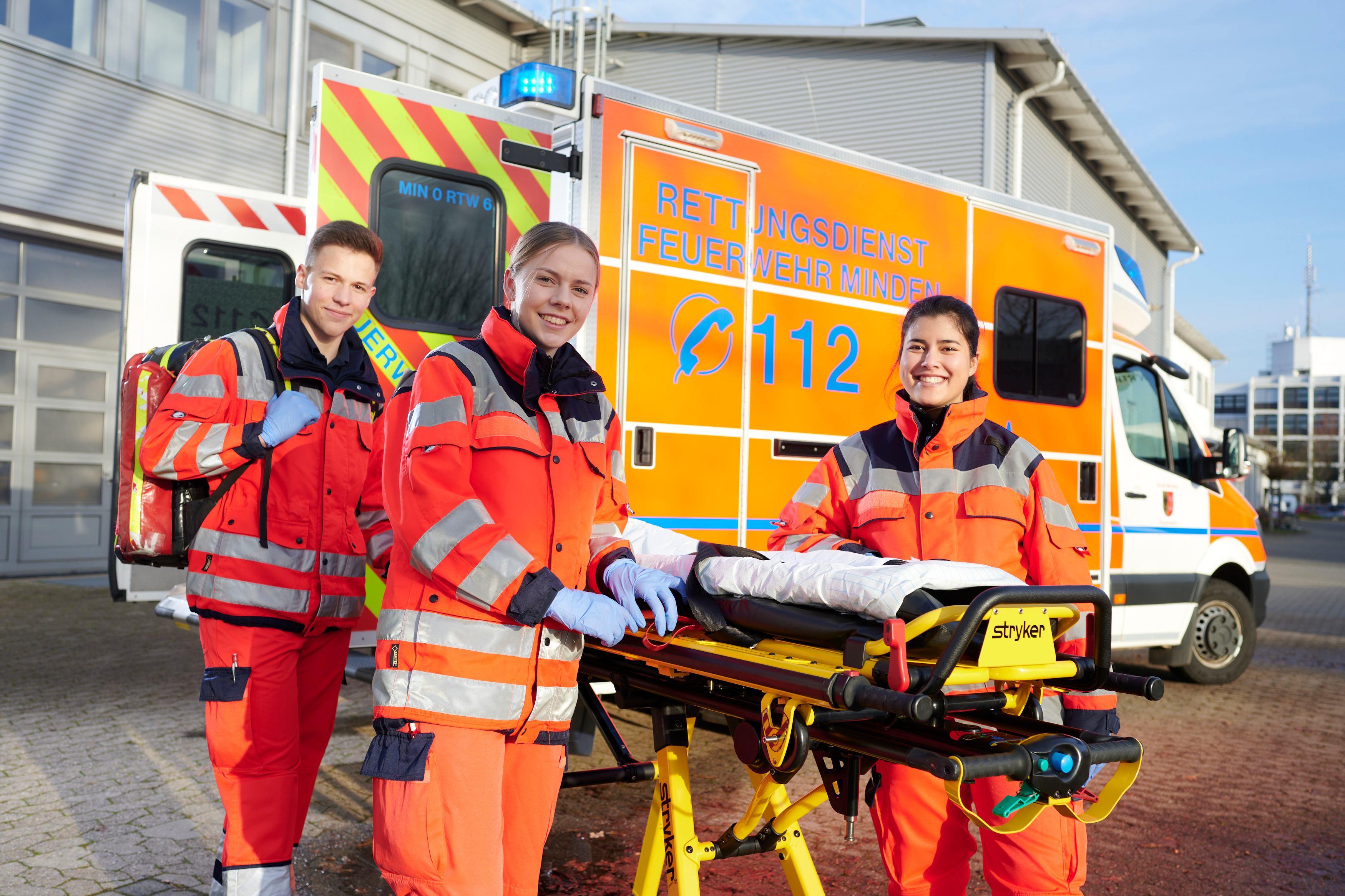 Junge Rettungssanitäter*innen vor einem Rettungswagen