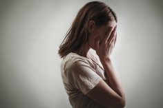 Gewalt gegen Frauen Verzweiflung Depression Frau hält verzweifelt Hände vors Gesicht
