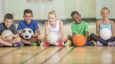 Kinder sitzend beim Sport Kinder sitzen in einer Gruppe beim Sport.