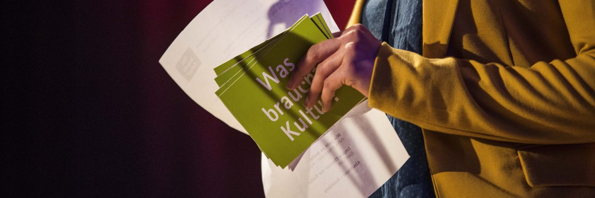 Moderatorin hält Karte und Mikrofon in der Hand