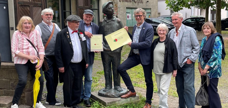 Gruppenbild von der Logo-Übergabe an der Skulptur des Mindener Buttjers