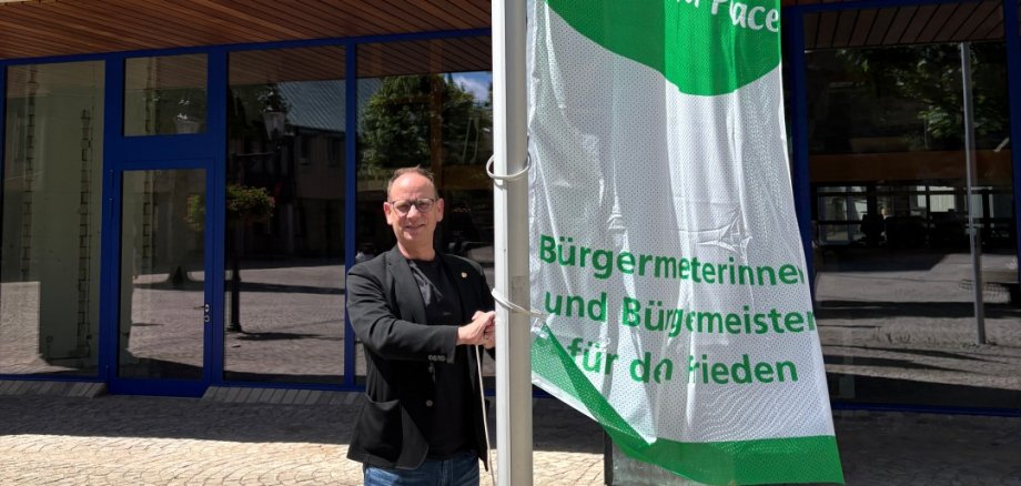 Bürgermeister Peter Kock hisst zum Mayors for Peace-Tag die Flagge am Rathaus Bürgermeister Peter Kock hisst zum Mayors for Peace-Tag die Flagge am Rathaus