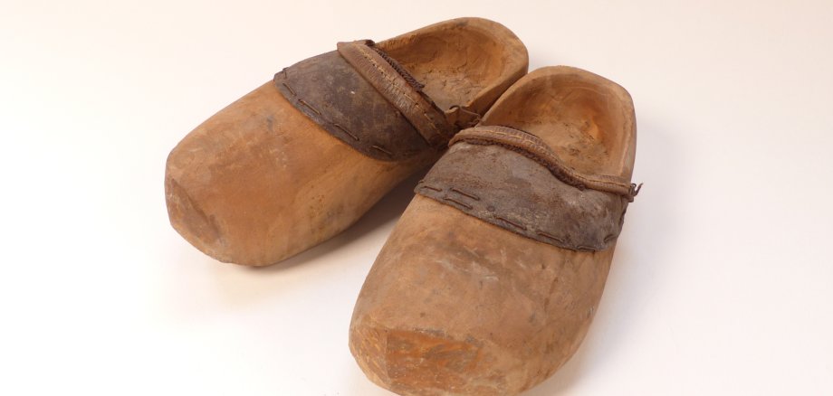 Ein paar Kinder-Holzschuhe aus einer Mindener Fabrik stehen im Fokus