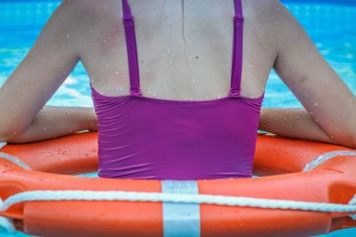 Frau mit Rettungswing im Schwimmbad