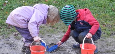 Kinder spielen draußen im Matsch