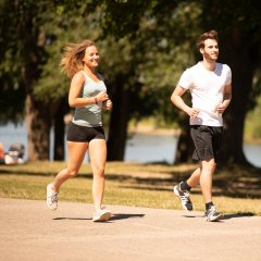 Eine Frau und ein Mann joggen auf der Weserpromenade